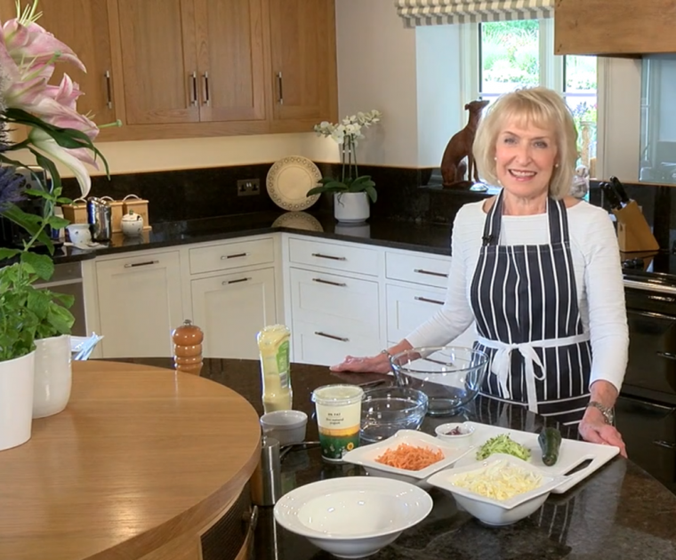 Rosemary Conley standing in her kitchen preparing her healthy home-made coleslaw