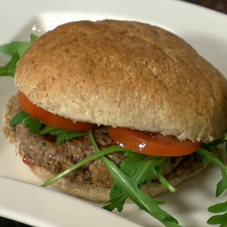 A healthy home-made beefburger with rocket and tomato in a wholemeal bun