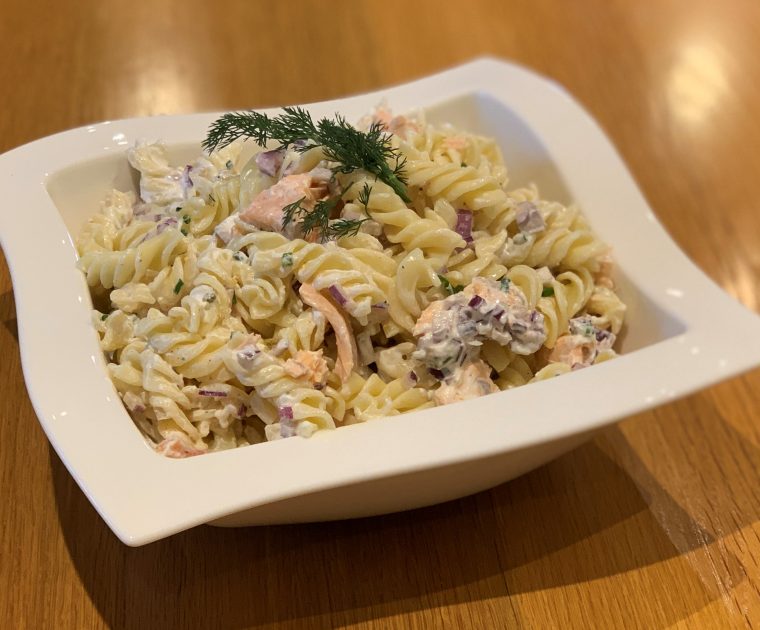 Fresh Salmon Pasta Salad in a white square dish garnished with dill