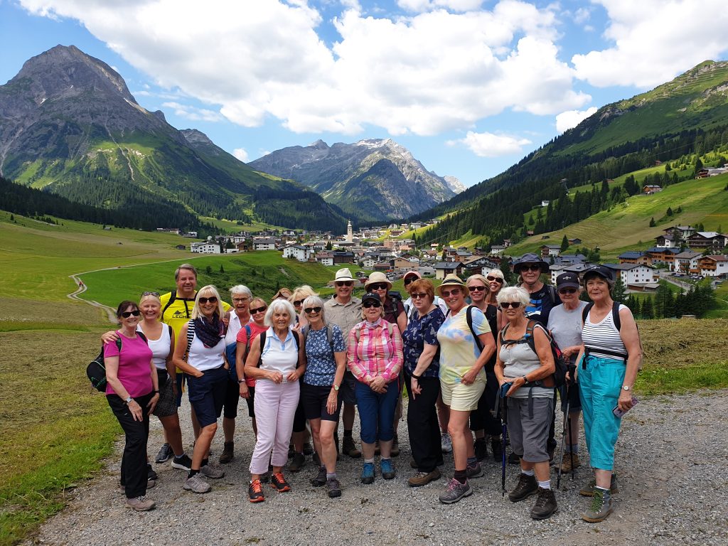 Austrian Activity Holiday group posed with the town of Lech behind them in the valley