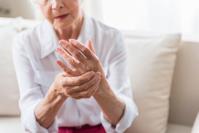 Elderly female expressing the pain of Arthritis in her hand