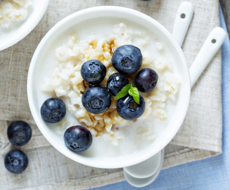 A bowl of rice pudding topped with blueberries