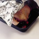 Season the turkey well with salt and freshly ground black pepper. Cover with foil and place in the oven.