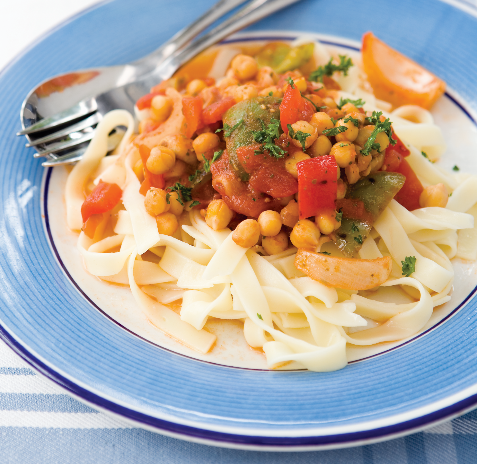 Roast Vegetable & Chickpea Pasta is a pasta dish topped with a tomato based sauce made with onion, garlic, cougettes, leek, peppers, chickpeas, pesto and soy sauce.