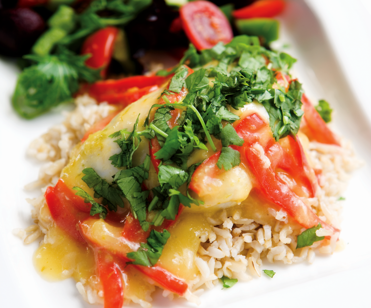 A plate of sweet chilli chicken on a bed of white rice with a mixed salad