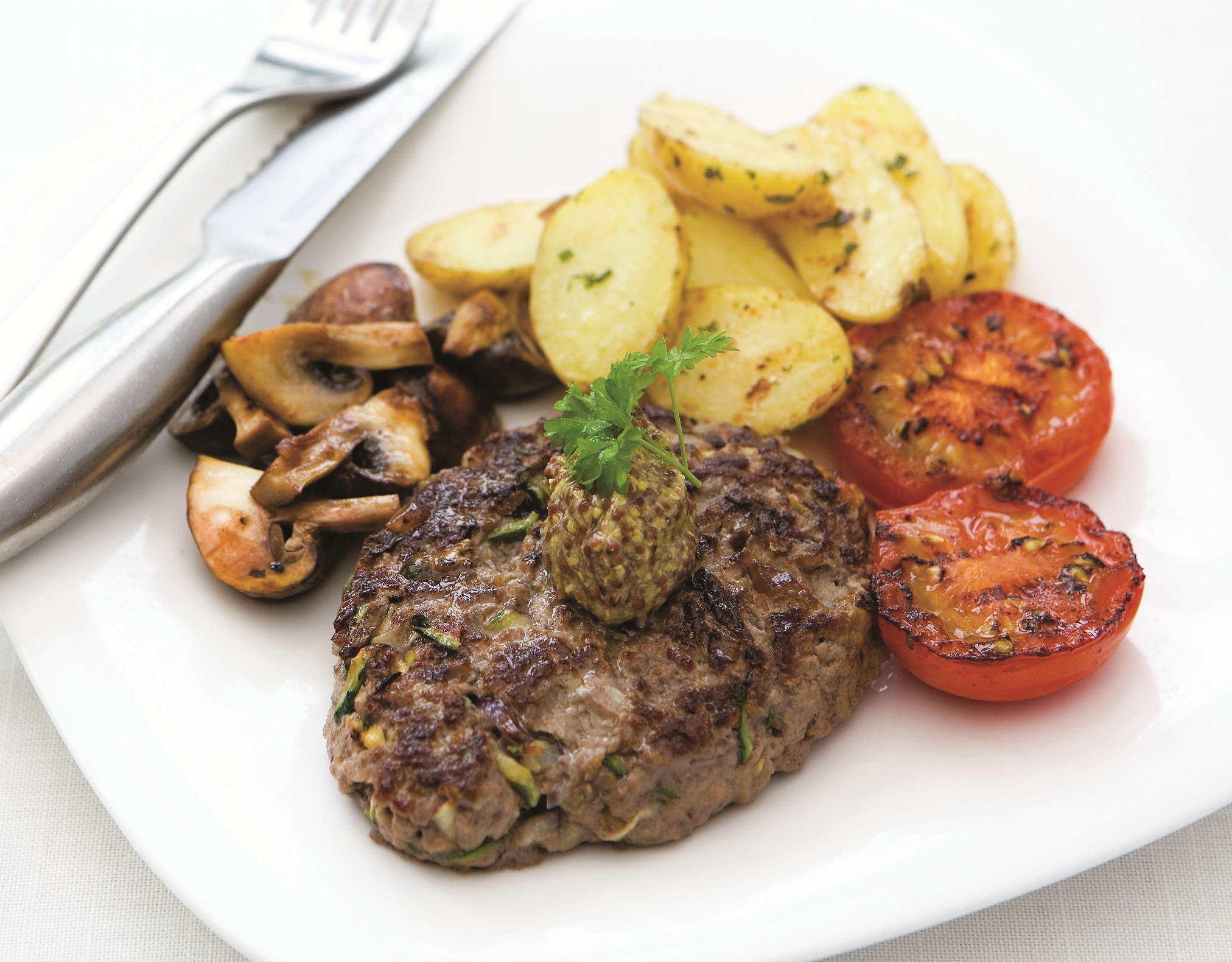 Minced Beef and Quorn Steaks are a homemade mix of meat and Quorn shaped into a burger and griddled, served here with grilled tomatoes, mushrooms and boiled new potatoes.