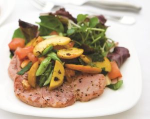 Gammon Steak with Peaches. The peaches are sliced with tomatoes and spring onions and served warm mixed with mint jelly on the top of the steaks accompanied by a side salad.