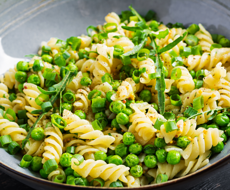 A bowl of Peas n Pasta with green peas and spring onion mixed with twists of pasta.