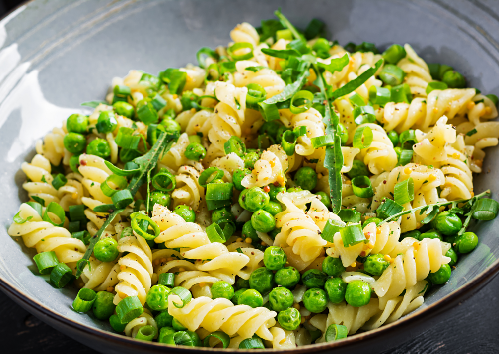 A bowl of Peas n Pasta with green peas and spring onion mixed with twists of pasta.