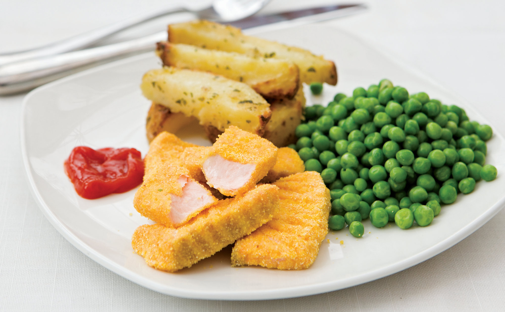 Salmon Fish Fingers are fingers of fresh oily fish coated in a polenta crumb and served with peas and chips.
