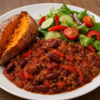 Spicy Beef with Beans and Tomatoes is a variation of Chilli-con-Carne, served with a jacket sweet=potato and a side-salad